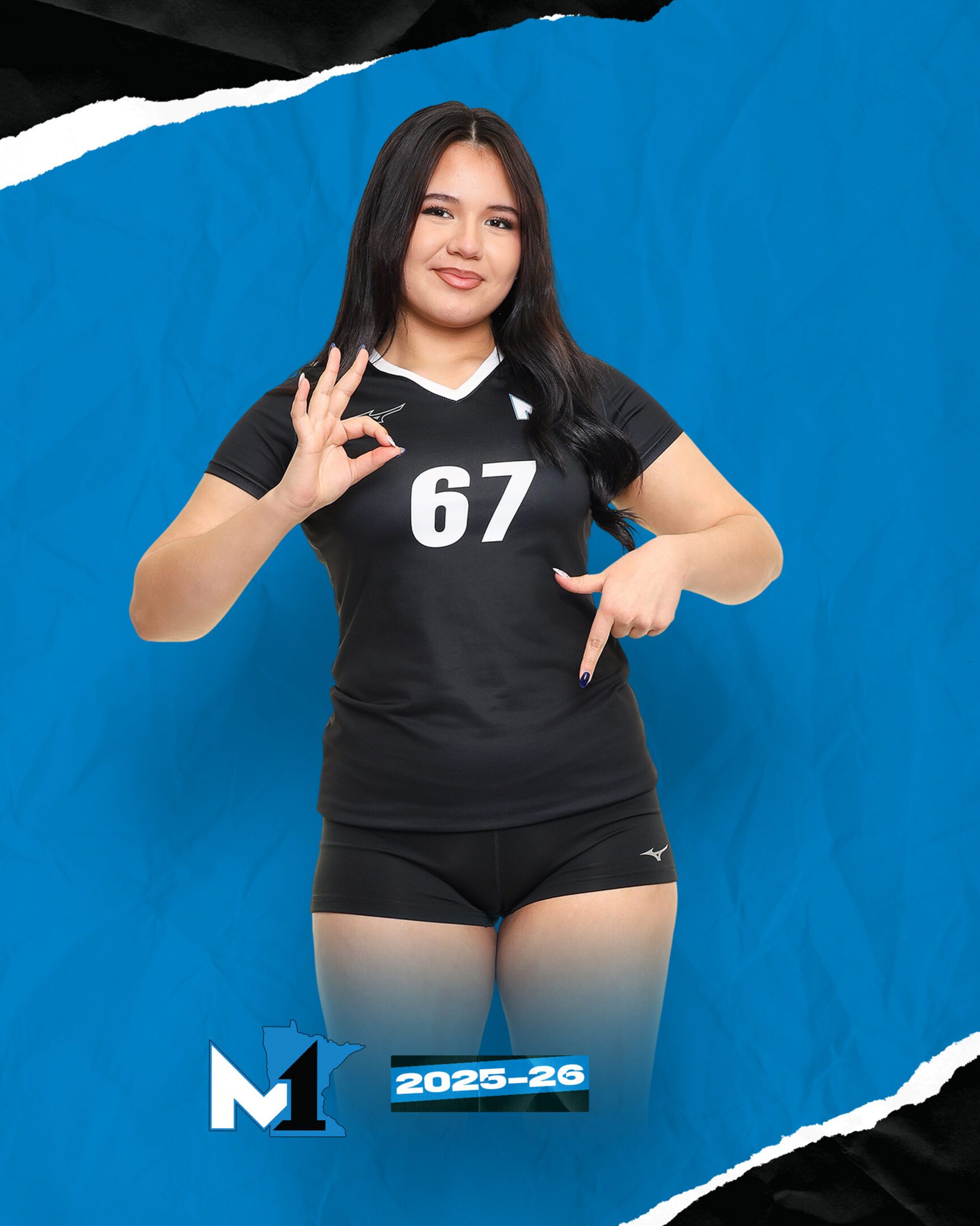Female volleyball player in black uniform making hand signs against a blue background.