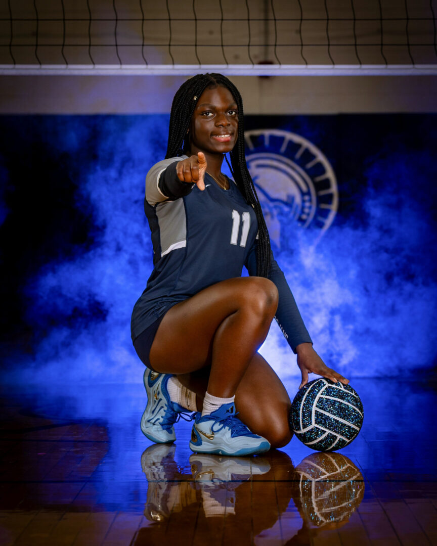 Athlete confidently posing with a volleyball.