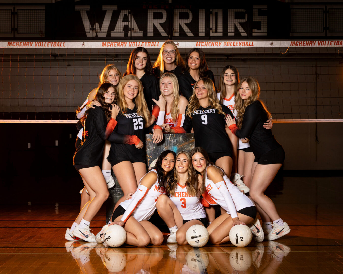 Volleyball team posing together in gym.