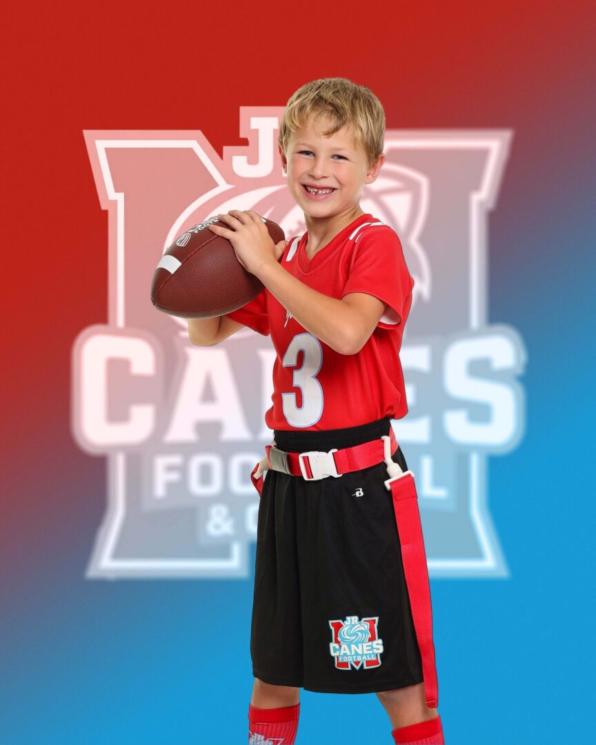 Smiling boy holding a football confidently.